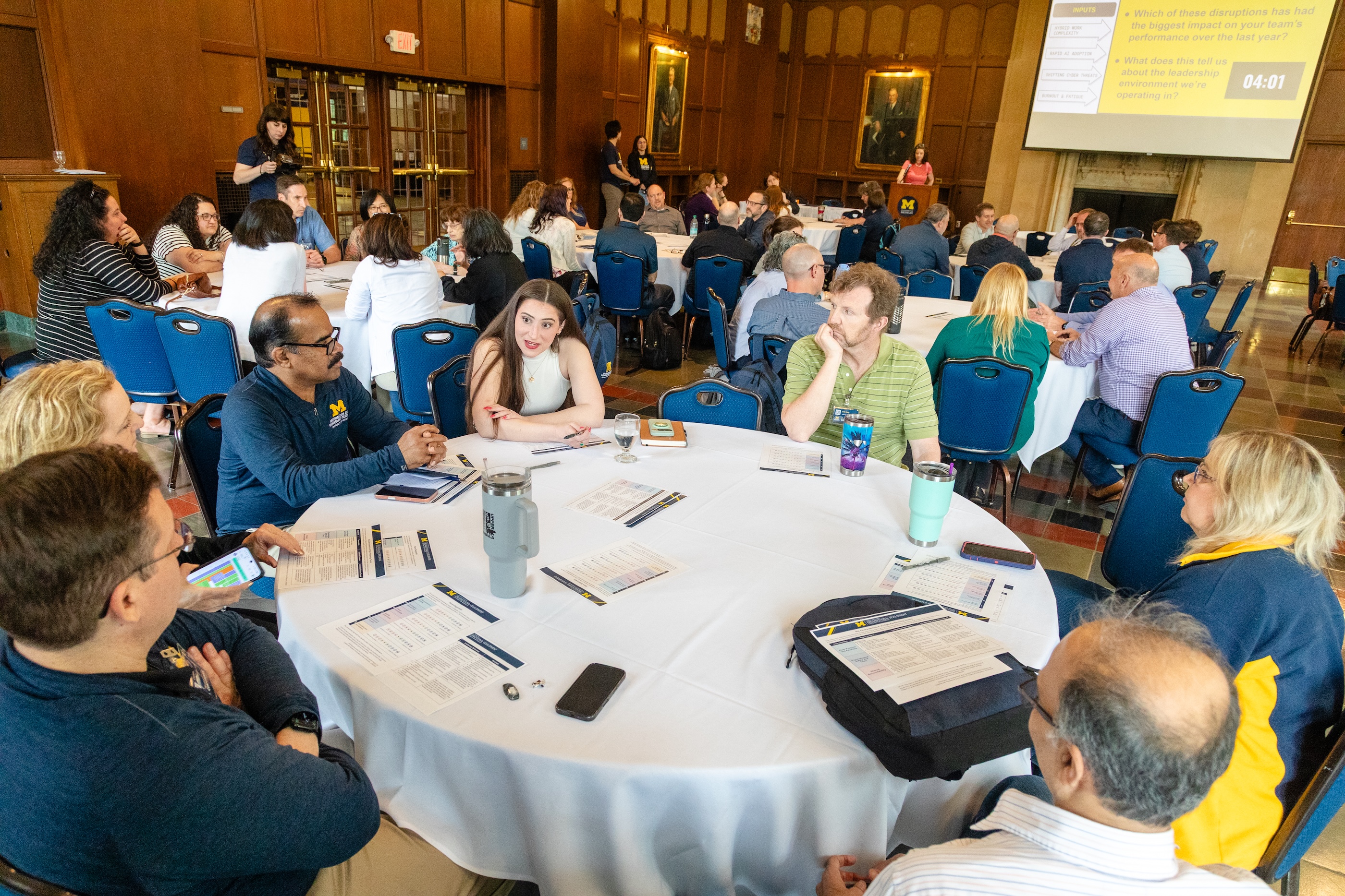 A close-up of a conference attendees in discussion sitting around a large circular table.