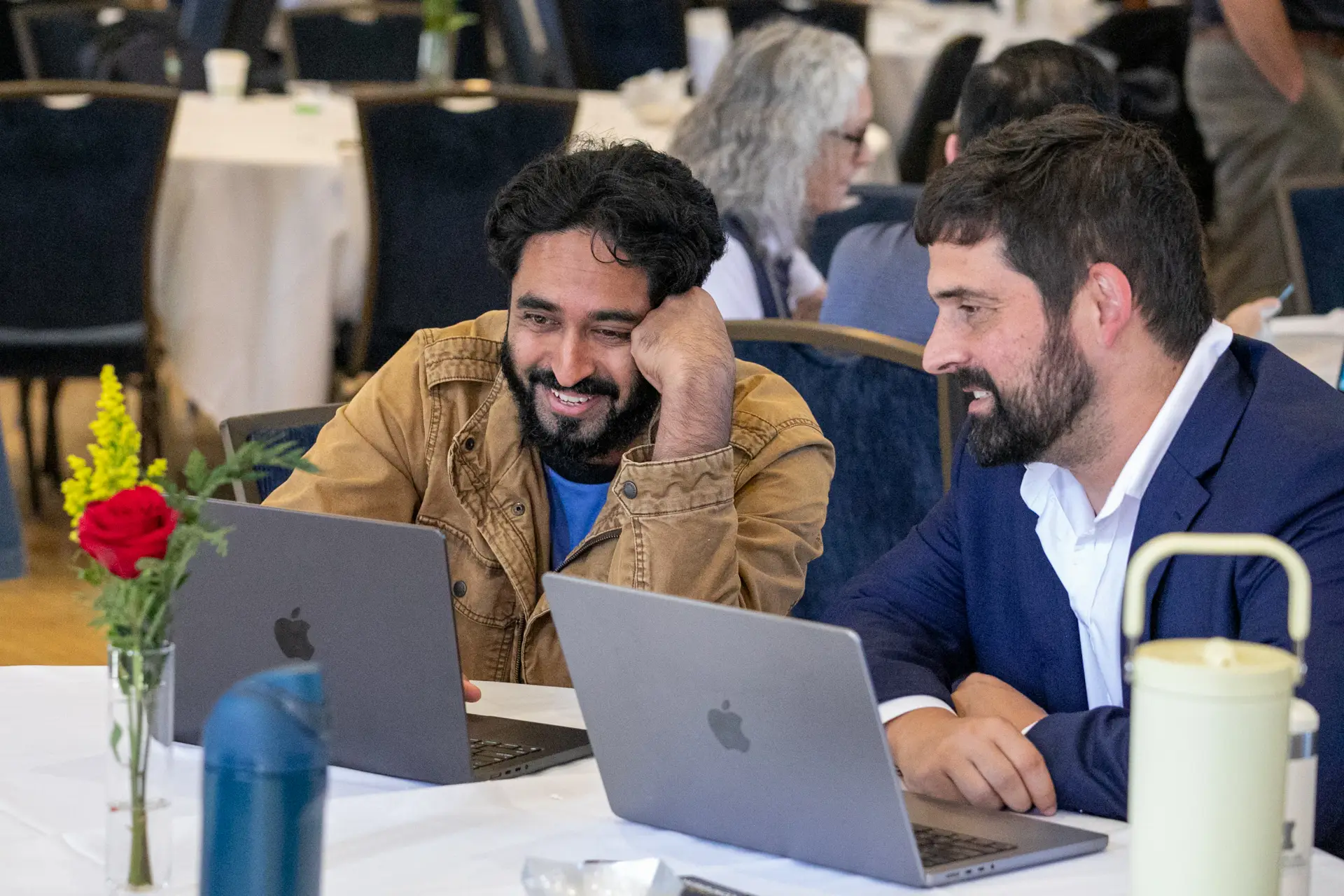 Attendees having a discussion with their laptop computers open.